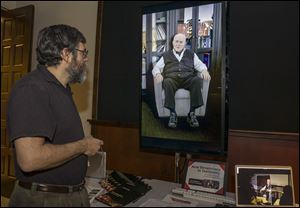 University of Southern California Institute for Creative Technologies, computer scientist David Traum, left, interacts with Holocaust survivor, Pinchas Gutter, seen on a 