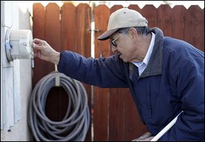 PG&E employee Art Liscano, 66, reads a meter at a house in Clovis, Calif. The number of meter readers in the U.S. fell from 48,000 in 2000 to 36,000 in 2010. Every day, PG&E  replaces 1,200 old-fashioned meters with digital versions that can collect information without human help, generate more accurate power bills, and even send an alert if the power goes out.