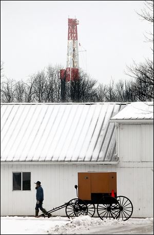 A Chevron rig drills for natural gas behind the property owned by the Mast family of New Wilmington, Pa.  Energy companies are leasing land throughout western Pennsylvania and eastern Ohio where Amish families like the Masts live. 