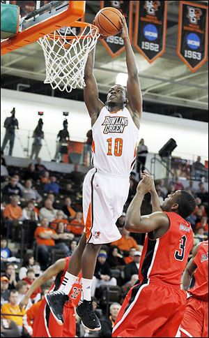 Bowling Green’s  Craig Sealey dunks over Ball State's Marcus Posley during Saturday’s game at BGSU. The Falcons came away with a 70-59 victory.