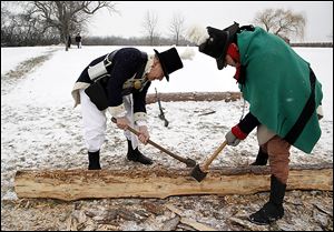 Re-enactors Dick Micka, left, of Monroe and Kenneth Roberts of St. Clair Shores, Mich., cut logs to build a block house.