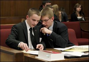 St. Francis student attorneys Hunter Mortemor, left, and Andy Rutkowski confer at the Ohio Center for Law-Related Education’s Ohio High School Mock Trial Competition in Toledo Municipal Court.