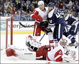 The Blue Jackets' Artem Anisimov scores against the Red Wings' Kent Huskins (3) and Jimmy Howard in the second period in Columbus. Anisimov scored twice.