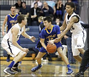 Findlay's Grant Niswander, center, is pressured by St. John's Jesuit's Austin Gardner, left, and Marc Loving during Friday’s game at St. John's. Gardner had 15 points while Loving added 12.