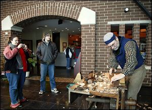 Jim Crammond, right,  demonstrates how to make a window frame as Jackie Cahoon and her brother, Alex Cahoon of Findlay, watch during the  200th anniversary celebration of Fort Meigs on Saturday. 