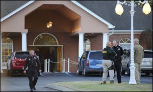 Law enforcement personnel wait outside the funeral home, Saturday, as people pay their respects to Charles Albert 