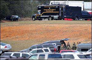 Federal and local law enforcement officers gather at their trucks after the hostage crisis ended in Midland City, Ala.  Officials say they stormed a bunker in Alabama to rescue a 5-year-old child being held hostage there after his abductor was seen with a gun.