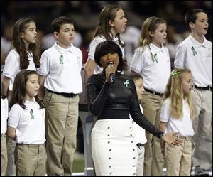 Jennifer Hudson, center, sings 'America the Beautiful' with the 26-member Sandy Hook Elementary School chorus. It was an emotional performance that had some players on the sideline on the verge of tears.