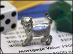  The newest Monopoly token, a cat, rests on a Boardwalk deed next to a die and houses at Hasbro Inc. headquarters, in Pawtucket, R.I.