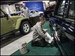  Detailer Joshua Pirrwitz, left, and Yark Automotive Group Detail Manager Karac Isom joke as they polish Jeeps before the start of the Greater Toledo Auto Show today at SeaGate Convention Centre in Toledo. The event runs through Sunday. Tickets are $6 for adults and $4 for those 55 and over.