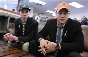 Drew Savage, left, and Jake Nachtrab, seniors at St. John's Jesuit High School in Toledo, talk about their friend and former classmate, Brian Hoeflinger, following a National Signing Day event. Savage will attend Ohio University and run cross country. Nachtrab will attend Bowling Green State University as a preferred walk-on on the football team.