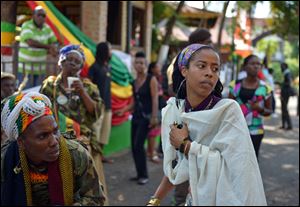 Bob Marley's granddaughter Donisha Prendergast, right, dances to the sound of a Rastafarian drum, during the celebration of Marley's 68th birthday today in the yard of his Kingston home, in Jamaica.