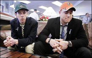 Drew Savage, left, and Jake Nachtrab, seniors at St. John’s Jesuit High School, talk about their friend and former classmate, Brian Hoeflinger of Ottawa Hills, after a national signing day event Wednesday. 