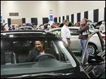  Kim Riley of Temperance checks out a Toyota Avalon on opening day of the 2013 Greater Toledo Auto Show at the SeaGate Convention Centre. Ms. Riley said she usually attends the North American Auto Show in Detroit too, but Toledo’s set-up is better for people looking to buy a new vehicle.