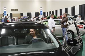 Kim Riley of Temperance checks out a Toyota Avalon on opening day of the 2013 Greater Toledo Auto Show at the SeaGate Convention Centre. Ms. Riley said she usually attends the North American Auto Show in Detroit too, but Toledo’s set-up is better for people looking to buy a new vehicle.