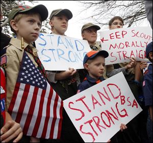 Clockwise from left,  Boy Scouts Eric Kusterer, Jacob Sorah, James Sorah, Micah Brownlee, and Cub Scout John Sorah hold signs at the “Save Our Scouts” Prayer Vigil and Rally on Wednesday at Scouts national headquarters in Irving, Texas. 