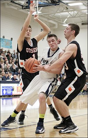 Lake's Connor Bowen (32) tries to get past Otsego's Tommy Rodgers (1) and Ryan Smoyer (23). Bowen scored a game-high 22 points in the win.