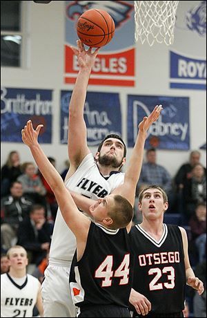 Lake's Marcus Pierce (54) takes a shot against  Otsego's John Thomas (44) and Ryan Smoyer (23) during Thursday’s contest at Lake High School. Pierce scored 14 in the win.