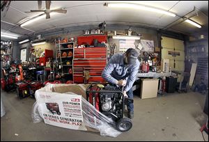 Chris Oppenberg of Andover Small Engine Service in Massachusetts assembles a home generator for a customer Thursday with a major winter storm headed toward the Northeast. The National Weather Service calls for up to 2 feet of snow.