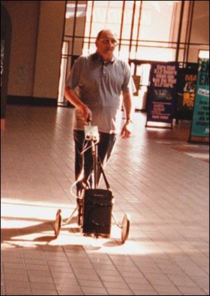 Butch Lemke's fight against beryllium disease includes walks with his oxygen tank attached to an old golf cart.
