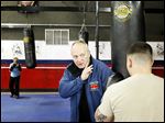  Executive director Harry Cummins works with a boxer on his form during practice at the International Boxing Club in Oregon. Cummins started the club 15 years ago.