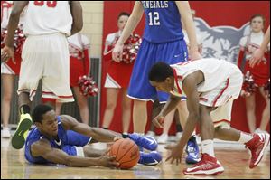 Bowling Green's sophomore LaMonta Stone (11) looses control of the ball as Anthony Wayne's senior Ose Omofoma (22) reaches in.