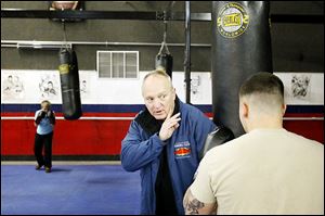 Executive director Harry Cummins works with a boxer on his form during practice at the International Boxing Club in Oregon. Cummins started the club 15 years ago.