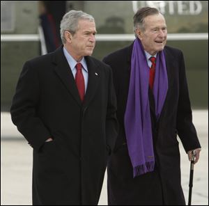 President George W. Bush walks with his father, former President George H.W. Bush, at Andrews Air Force Base, Md.