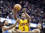  Cavaliers guard Dion Waiters (3) shoots between Denver's Wilson Chandler, left, and Kenneth Faried.