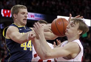 Michigan's Max Bielfeldt, left, and Wisconsin's Sam Dekker vie for a rebound during the first half of an NCAA college basketball game.