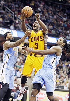 Cavaliers guard Dion Waiters (3) shoots between Denver's Wilson Chandler, left, and Kenneth Faried.