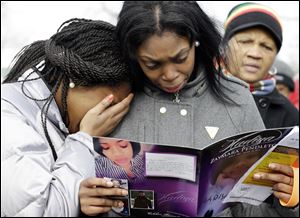 Danyia Bell, left 16, and Artureana Terrell , 16, react as they read a program for the funeral of Hadiya Pendleton outside the Greater Harvest Missionary Baptist Church after the funeral service of Hadiya Pendleton today in Chicago.