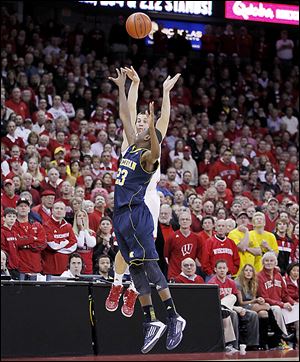 Wisconsin's Ben Brust shoots a long 3-pointer over Michigan's Caris LeVert in the final second of regulation to tie the game.