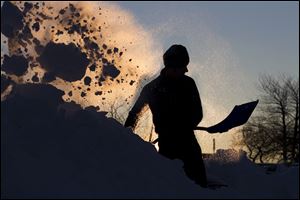 Peter Bloom digs his car out of a parking lot at sunrise Sunday in Portland, Maine. Residents are digging out after a blizzard dumped a record 31.9 inches of snow on the city.