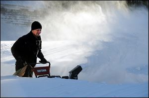 Tony Colon uses a snowblower to clear his driveway in Derby, Conn., as residents face massive snow removal, Saturday, following a severe blizzard that dumped up to three feet of snow across the state.