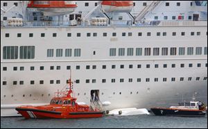 An orange rescue boat docks by a capsized lifeboat from the British-operated cruise ship Thomson Majesty in Santa Cruz port of the Canary Island of La Palma, Spain, today. 