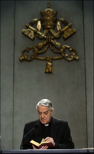 Vatican spokesman Father Federico Lombardi reads from 