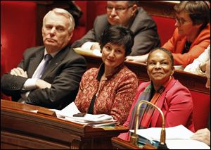 French justice minister Christiane Taubira, right, sits on the government bench with social affairs minister Dominique Bertinotti, center, and prime minister Jean Marc Ayrault, during the vote at the National Assembly in Paris of a new law legalizing gay marriage.