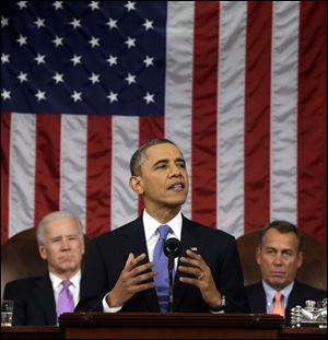 President Barack Obama, flanked by Vice President Joe Biden and House Speaker John Boehner of Ohio, gestures as he gives his State of the Union address during a joint session of Congress on Capitol Hill in Washington.