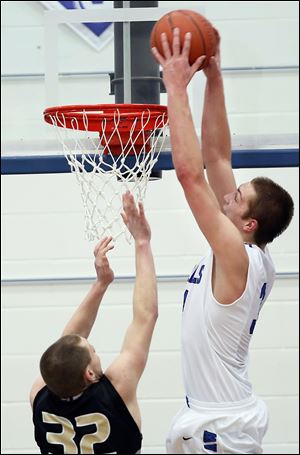 Anthony Wayne's Mark Donnal, right, dunks over Perrysburg's Chris Schimmoeller. Donnal finished with 13 points, 13 rebounds, and six blocked shots.