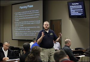 James Burke, a law enforcement training officer with the state Attorney General's Office, conducts a training session for educators on how to react if a shooter is inside a school.