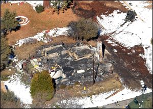 In this aerial photo, law enforcement authorities investigate the burnt-out cabin today where accused quadruple-murder suspect Christopher Dorner was believed to have died after barricading himself inside, during a Tuesday stand-off with police in the Angeles Oaks area of Big Bear, Calif. 