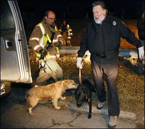 Deputy dog warden Ron Cannon takes the two dogs who  were stranded on the ice all day, into custody late today.