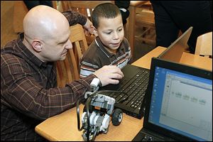 Todd Beavers, educational technology teacher, helps first grader Alex Brown program a Lego robot during Lego Club at Glenwood Elementary School. 