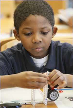 Fourth grader Kobe Rios, 10, builds a component for a Lego project during Lego club at Glenwood Elementary School on Friday.