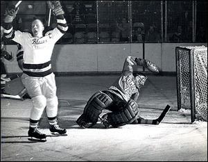 The Blades' Chick Chalmers raises his arms in typical hockey fashion after he scores a playoff goal against Ft. Wayne Komets goalie Chuck Adamson.