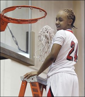 Cha'Ron Sweeney, who scored 20 points, cuts down the net after Rogers defeated Waite to win the City League girls basketball championship for the second straight year.