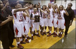 Cha'Ron Sweeney holds the City League girls basketball championship plaque as the team celebrates. The Rams are 19-3.