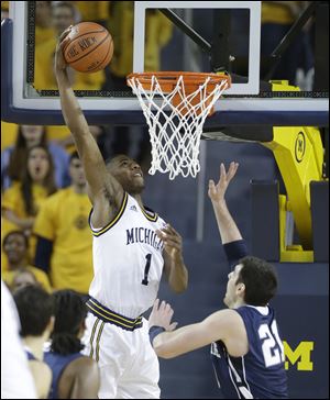 Michigan forward Glenn Robinson III dunks over Penn State guard Nick Colella during the first half Sunday in Ann Arbor. Robinson matched a career high with 21 points and Trey Burke scored a season-high 29 to help the Wolverines get past a humbling setback with a 79-71 victory over Penn State.