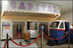 A 1959 Eshelman Motor Corp. mail vehicle is parked in front of a mockup of the Capitol Theatre at the Delphos Museum of Postal History.